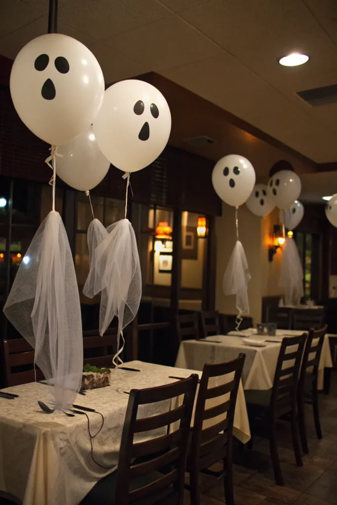 9 floating white ghost balloons tied to dining c